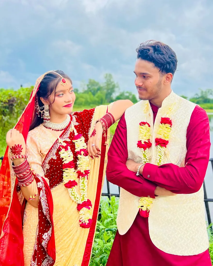 The bride resting her arm on the groom's shoulder as they smile at each other