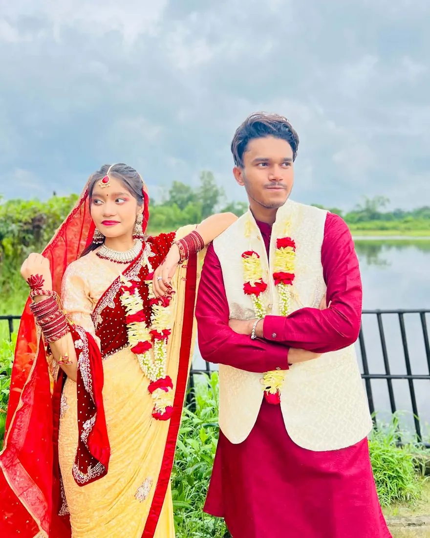 The couple looking out in the same direction, her arm on his shoulder